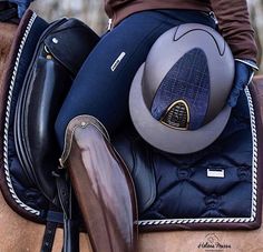 a woman riding on the back of a brown horse with her saddle and boot in place