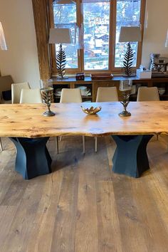 a large wooden table sitting in the middle of a living room next to a window