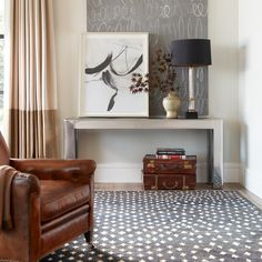 a living room with a chair, table and pictures on the wall