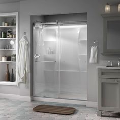 a bathroom with a walk in shower next to a sink