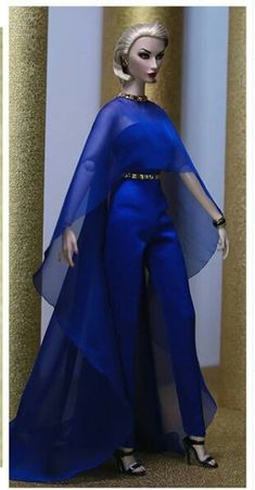 a barbie doll wearing a blue dress and cape