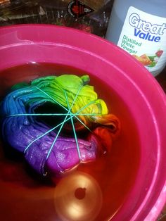 a pink bowl filled with liquid and colorful items