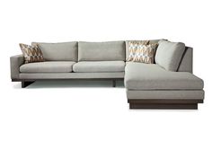 a large sectional couch with pillows on the back and side facings, sitting in front of a white background