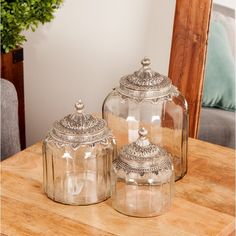 two glass jars sitting on top of a wooden table