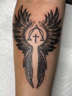 an angel wing with a cross on it and wings around the center of the arm