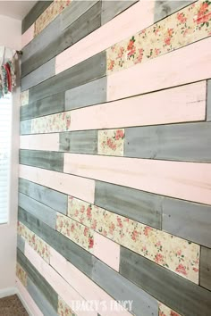 a wall made out of wood planks with flowers painted on the side and white paint