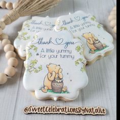 three winnie the pooh cookies with thank you written on them and some tassels