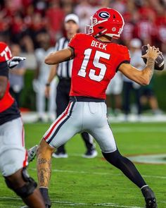 a football player is getting ready to throw the ball while others watch from the sidelines