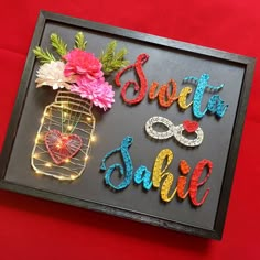 a framed sign that says sweet sale with flowers in a jar and lights on it