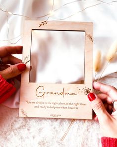 two hands holding a wooden frame with the words grandma on it