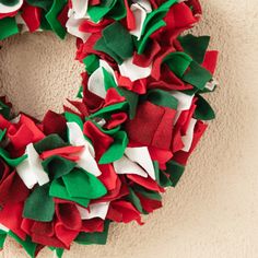 a red and green christmas wreath hanging on the wall