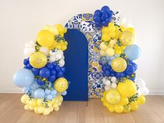 a blue and yellow arch with balloons on it