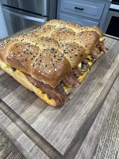 a large sandwich sitting on top of a wooden cutting board