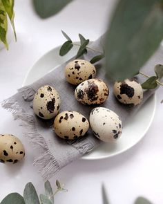 quails and leaves on a white plate with a gray napkin next to them