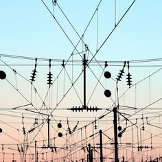 many power lines and wires against a blue sky