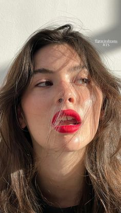 a woman with long hair and red lipstick