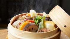 steaming food in a bamboo steamer on a table