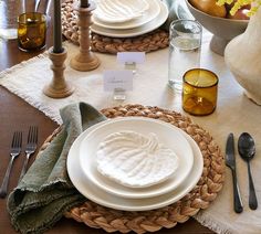 the table is set with plates, silverware and napkins for an elegant dinner