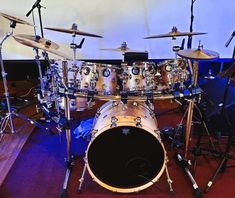 a drum kit is sitting on the floor in front of a wall with blue lights