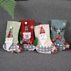 christmas stockings with santa claus and snowmen on them are sitting on a gray couch