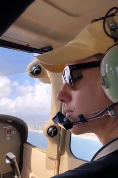 a man wearing a pilot's helmet and goggles in the cockpit of a plane