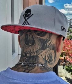 a man with a skull and crossbone tattoo on his neck wearing a baseball cap