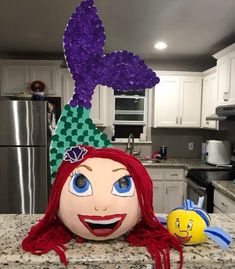 a large stuffed doll sitting on top of a kitchen counter