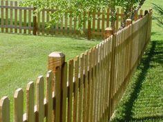 a wooden fence in the middle of a grassy field