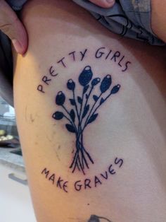 a woman with a tattoo on her thigh that says pretty girls make graves and flowers