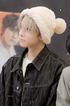 a young man wearing a white hat and jacket