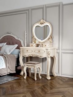 a bedroom with a bed, dresser and mirror on it's side in front of a gray wall