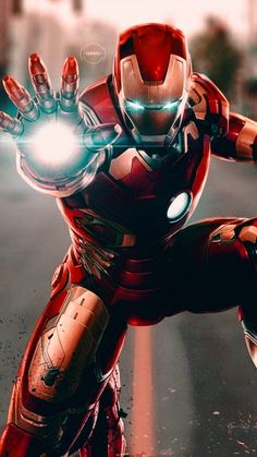 an iron man in the middle of a street with his hands out to light up