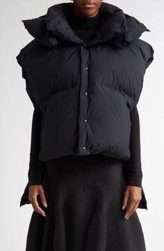 Oversizing and asymmetry serve function as well as fashion purposes for this down puffer vest. A drop-tail hem provides protection from the cold to the upper thighs, with the cropped front warming your core without obscuring the outfit beneath. Extended shoulders and a voluminous hood ensure an on-brand silhouette for the style. 23" front length; 34" back length (size 12) Front snap closure Stand collar Fixed hood Front welt pockets Drop-tail hem Side slits with snap closures Lined, with 90% dow Fitted Nylon Winter Vest, Fitted Sleeveless Outerwear With Padded Collar, The Outfit, Puffer Vest, Welt Pockets, Stand Collar, Clothing Items, Snap Closure, Puffer