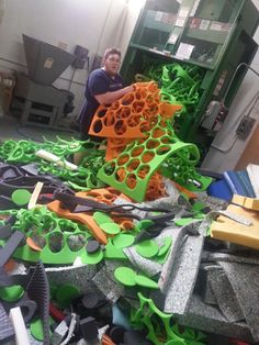 a man standing next to a pile of green and orange objects