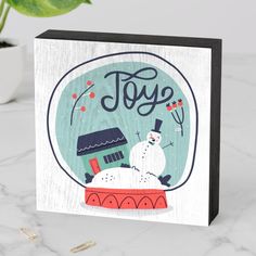 a christmas card with a snowman in a snow globe and the word joy on it