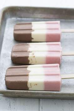 three popsicles sitting on top of a metal tray