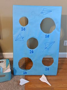 a blue bag with holes and numbers on it sitting on the floor next to a cardboard box