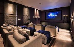 a home theater with couches, chairs and a projector screen on the wall