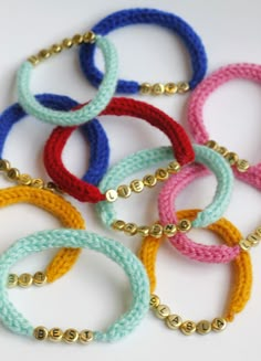 several bracelets with gold beads are shown on a white surface and have different colors