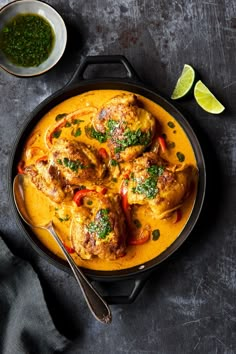 a pan filled with chicken curry and garnished with cilantro