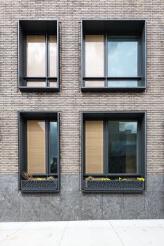 three windows on the side of a brick building