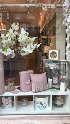 a window display with vases, pillows and other items in the windows sill