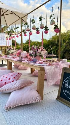 a table set up with pink and white decorations