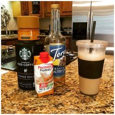 a cup of coffee and some drinks on a counter