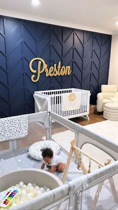 a baby in a white crib next to a blue wall with the word preston on it