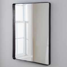 a mirror hanging on the wall next to a window