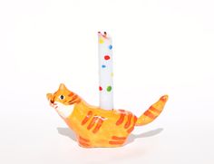 an orange cat figurine holding a candle