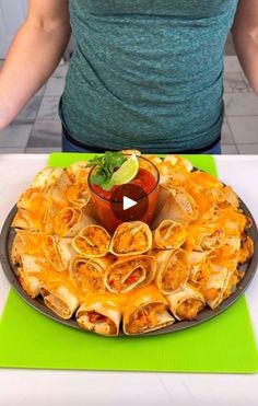 a person standing in front of a platter of food on a green place mat