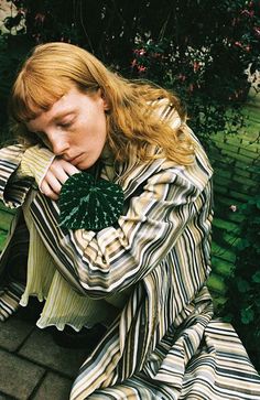 a woman sitting on the ground with her head in her hands