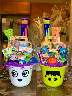 two buckets filled with toys and decorations on top of a table